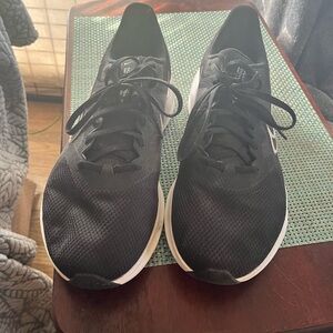 This is a pair of Nike Downshifter 11 W running shoes in black with a white sole